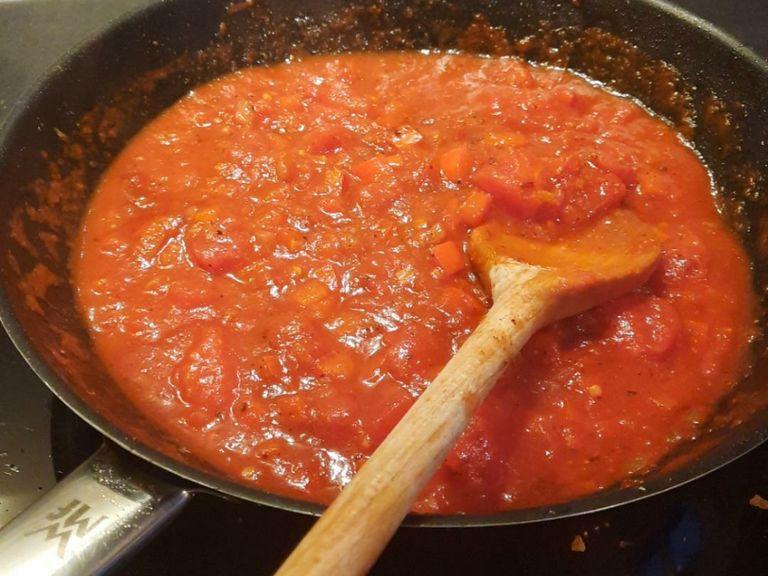 Add tomato paste and sugar into the pan and keep sautéing, approx. 2 min. Deglaze with red wine. Add crushed tomatoes and simmer for approx. 7 – 10 min. Season to taste with salt, pepper, and chili powder.