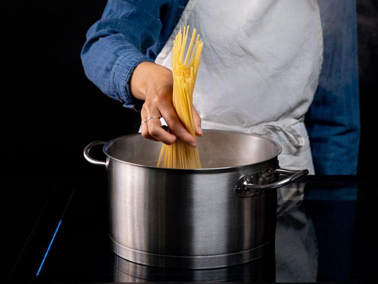 Wasser in einem großen Topf aufkochen lassen und salzen. Spaghetti nach Packungsanleitung kochen. Vor dem Abgießen einen Teil des Kochwassers abschöpfen und beiseitestellen.