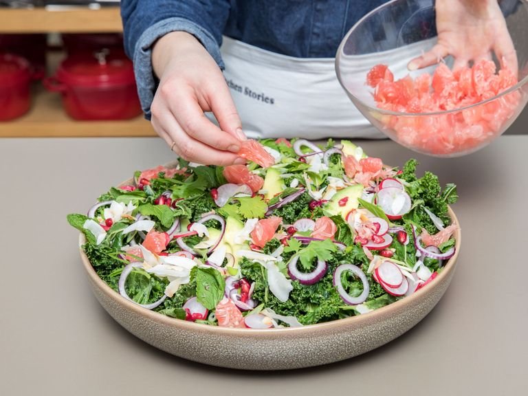 Arrange the kale in a big serving bowl and massage well with the dressing. Let sit for at least 10 min. Serve with red onion, radishes, scallion, mint, cilantro, coconut flakes, pomegranate seeds, pink pomelo, and avocado. Enjoy!