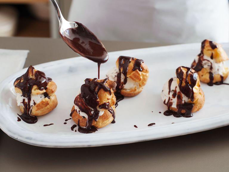 To serve, slice profiteroles horizontally, then fill each with a ball of ice cream. Serve profiteroles with a generous drizzle of chocolate sauce. Enjoy!