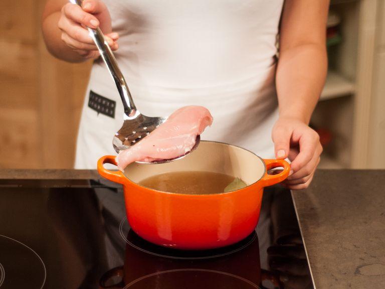 Hühnerbrühe mit Lorbeerblatt in einem großen Topf zum Kochen bringen und auf ein Köcheln reduzieren. Hühnerbrust hinzugeben und ca. 5 – 10 Min. pochieren, bis sie gar ist. Aus dem Topf nehmen und abkühlen lassen.