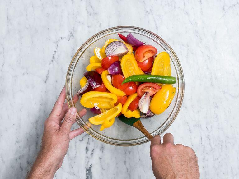Pre-heat oven to 240°C/460°F. Halve bell peppers and remove the core. Wash tomatoes and peel onions. Quarter bell peppers, tomatoes, and onions. Add vegetables together with olive oil to a large bowl, season with salt and mix well.