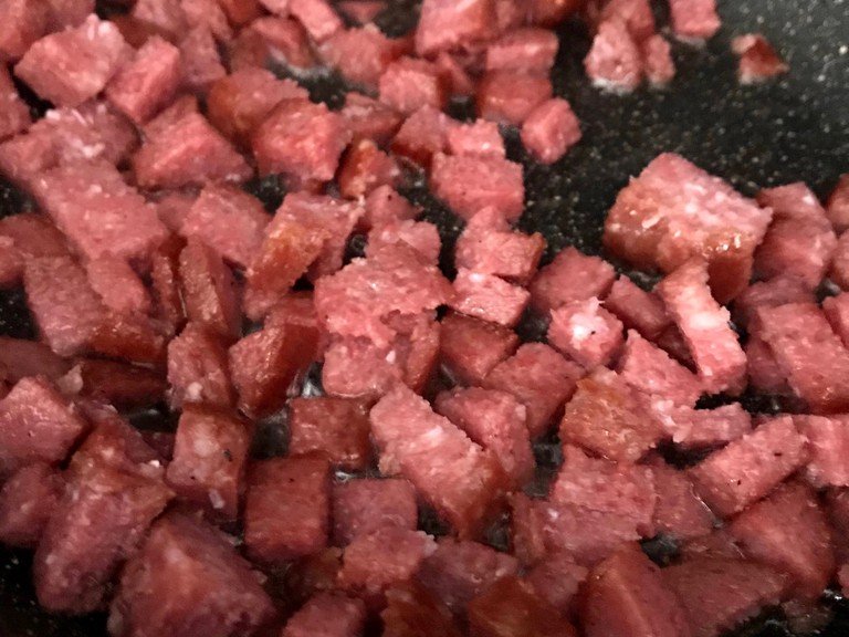 Fry the salami until crispy and drain on a paper towel until cool. Crumble into small bits,then place them into a large bowl.