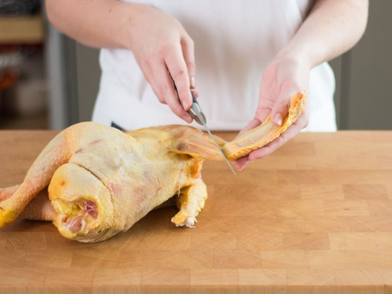 Wash and dry the chicken. Cut the wings at the joint and remove cartilage at the end of the drumsticks. Stuff chicken with onions, parsley and half of each the garlic, rosemary and thyme. Truss the chicken by tying the end of the drumsticks together with cooking twine.