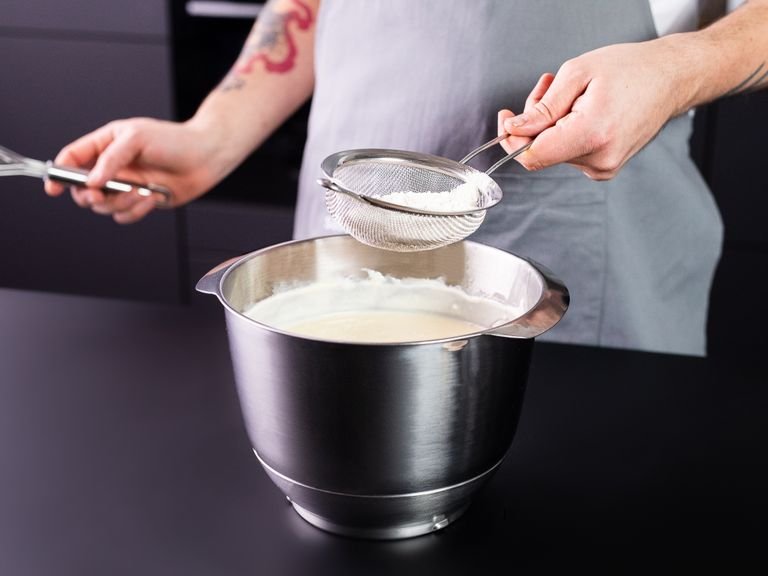 Den Frischkäse mit Zucker in der Küchenmaschine mit Paddelaufsatz für ca. 2 Min aufschlagen, bis sich der Zucker vollständig aufgelöst hat.