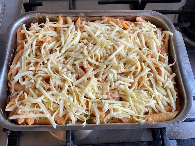 Add the pasta with sauce to a butter greased roasting pan. Top with grated mozzarella cheese and put in oven. (Preheated at 180 degrees Celsius). Bake for 20 min.