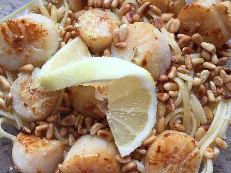 Mix the hot pasta with the with lemon-oil mixture. Serve with pine nuts, basil, and scallops. Enjoy!