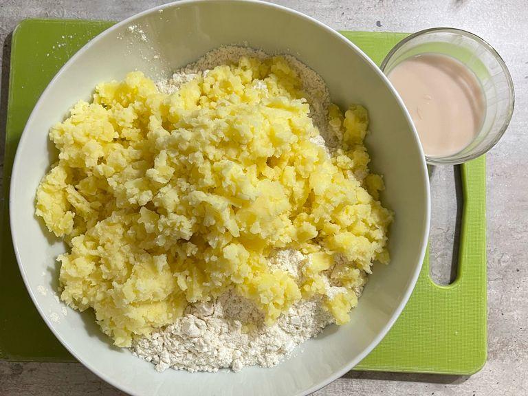 Add the flour, the smashed potatoes and salt into a bowl. Then melt the yeast in warm water and add this to the rest of the ingredients. 