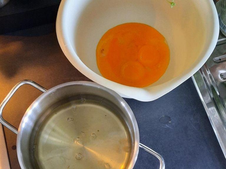 Backofen auf 180°C Umluft vorheizen. Die Eier trennen. Das Eigelb in eine große Schüssel geben und mit Wasser schaumig schlagen. 75g Zucker und Vanillezucker langsam einrieseln lassen und weiter schaumig schlagen.