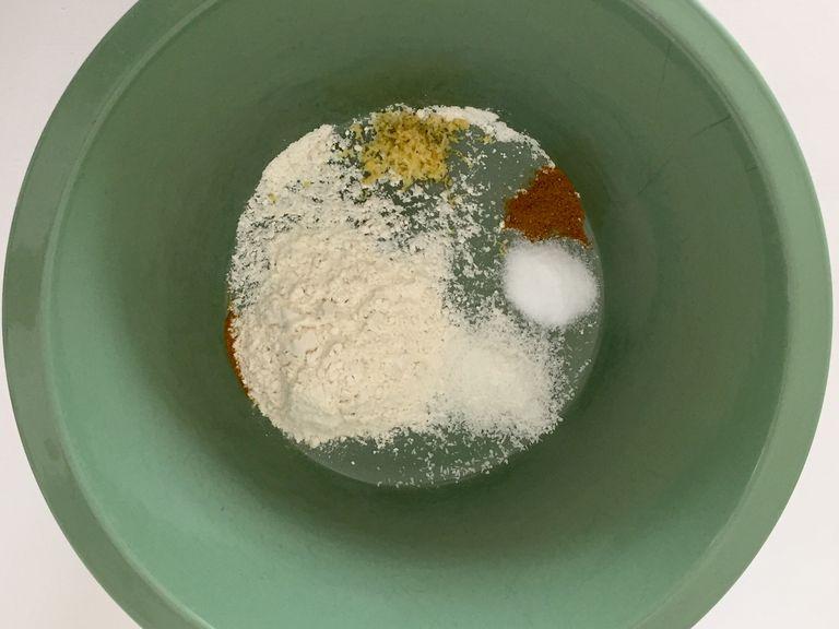 Mehl, Kokosraspeln, Zitronenschale, Currypulver und 1 Tl Salz in eine Schüssel geben. Alles gut vermischen