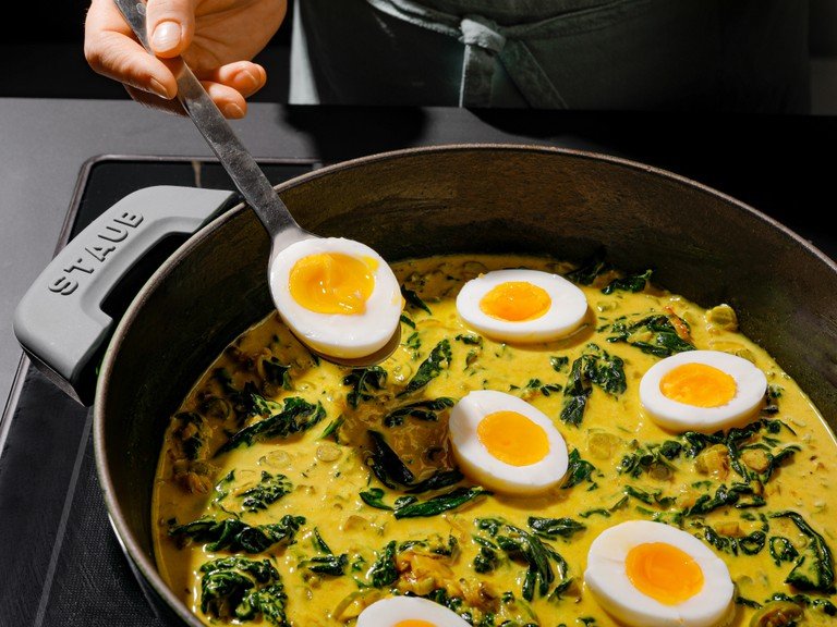 Peel and slice eggs through the center and transfer to the coconut-turmeric gravy. Let warm through. Remove from heat and garnish with fresh lime zest, sliced chilis, and cilantro leaves. Serve with basmati rice and extra lime wedges. Enjoy!