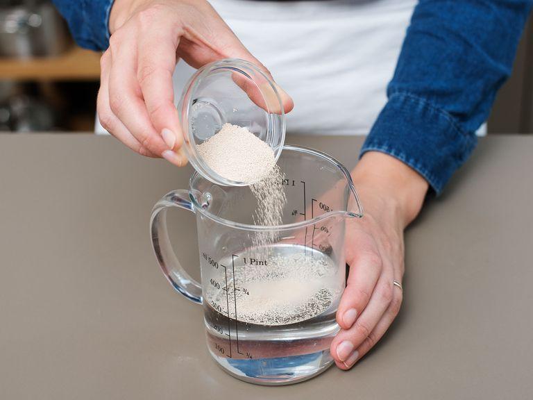 In einer großen Schüssel Wasser, Zucker und Hefe vermengen und für ca. 5 Min. beiseitestellen.