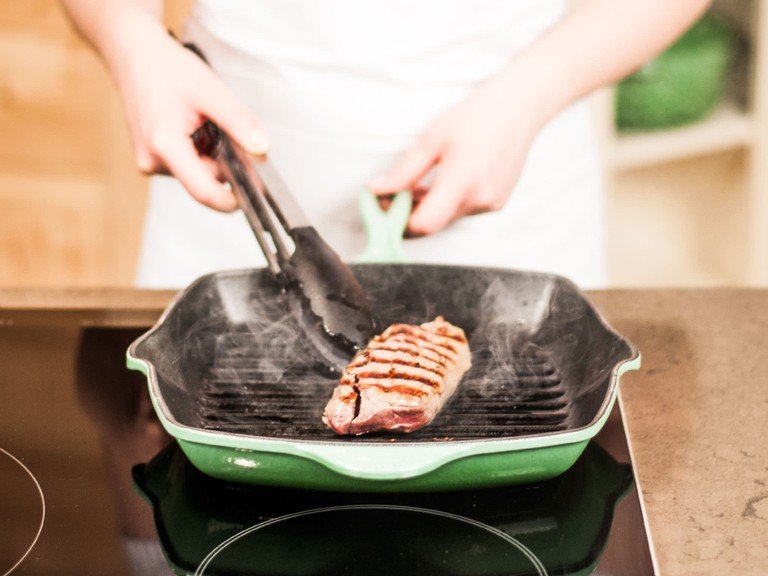 Backofen auf 60°C vorheizen. Das Steak auf beiden Seiten mit Öl beträufeln und im Ofen ca. 15. Min. vorgaren. Fleisch aus dem Ofen nehmen und ca.  2 Min. von jeder Seite grillen. Ca. 5 – 10 Min. auf einem Teller, abgedeckt mit Alufolie, ruhen lassen. Mit Salz und Pfeffer würzen.
