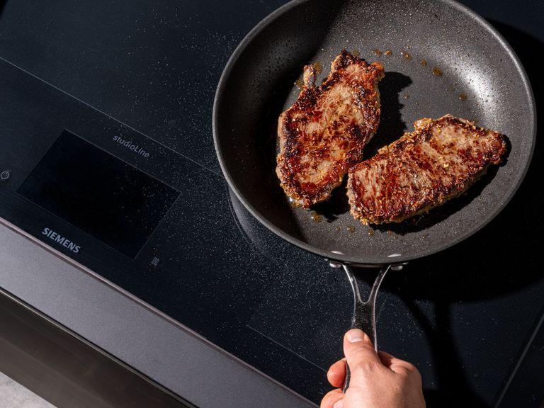 Eine gusseiserne Pfanne mit etwas Pflanzenöl auf mittlerer Stufe erhitzen. Die Steaks hineingeben, dabei die Zitronengrasstücke aus der Marinade wegbürsten und auf jeder Seite ca. 3 Min. braten, bis die Steaks medium oder medium rare sind. Auf ein Schneidebrett legen und mindestens 5 – 10 Min. ruhen lassen. Nach dem Ruhen entgegen der Faserrichtung in dünne, ca. ½ cm dicke Scheiben schneiden.