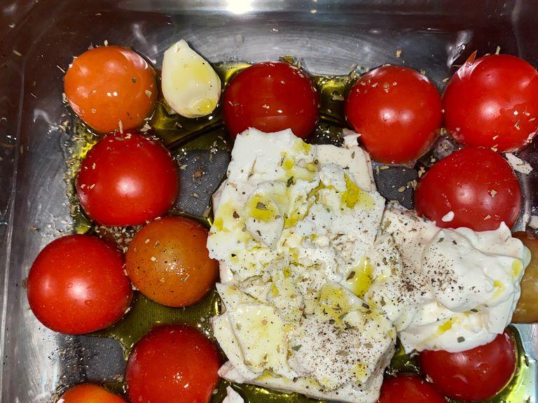 To a pan add sliced in half cherry tomatoes, 2-3 cloves of garlic, a block of Feta Cheese, a tbs of sower cream or cream cheese and some oregano and drizzle the extra virgin olive oil all over it. Add salt if the feta cheese is not salty enough.