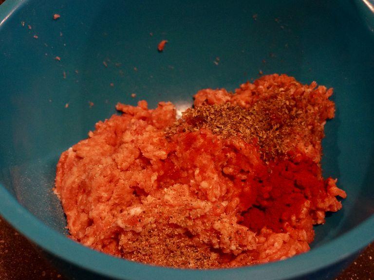 Add dried basil, paprika, salt, pepper to the minced meat. Mix everything thoroughly and add to the saucepan. Simmer for about 5 minutes