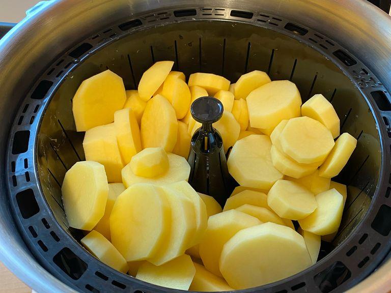 Wasser bis zur Dampfgarmarkierung in den Cookit-Topf einfüllen und 1 TL Salz hinzugeben. Die Kartoffeln schälen, in 0,5 cm dicke Scheiben schneiden und in den Dampfgareinsatz geben. Einsatz in den Topf setzen. Deckel des Topfes entfernen.