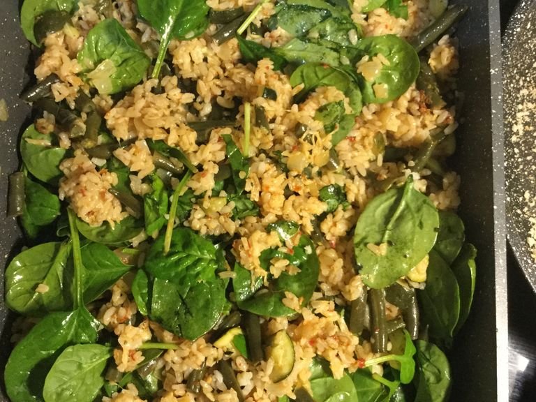 When the risotto is done, stir through the red pesto and the grated parmesan. Lastly, fold in the spinach leaves.