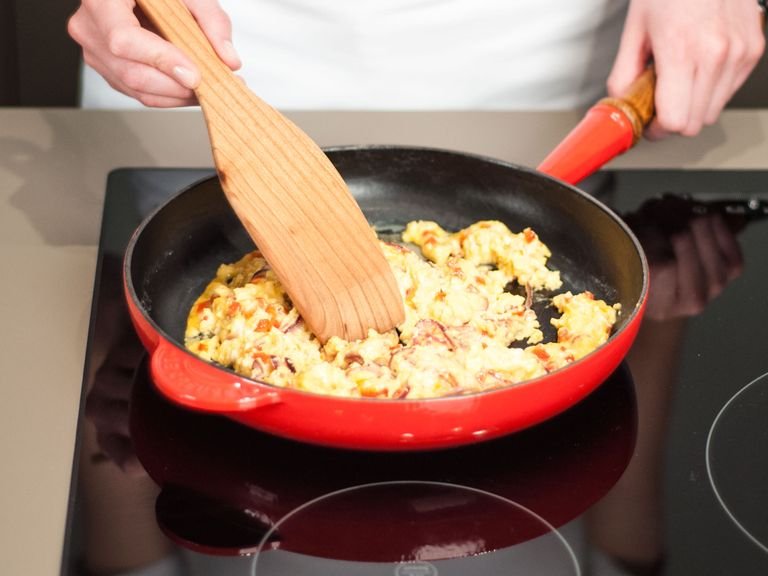 Eier in die Pfanne geben und weiter für ca. 3 – 5 Min. anbraten, gelegentlich umrühren. Käse zugeben und umrühren bis dieser geschmolzen ist.