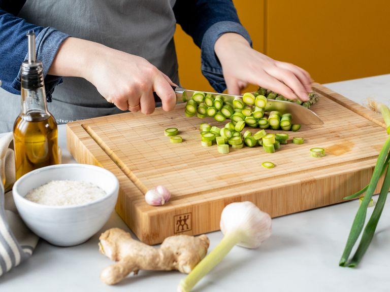 Remove tough ends from asparagus, slice off the tops, and then slice the length into small rounds approx. 0.5 cm/0.25 in. wide. Set aside. Finely grate a third of the ginger, grate garlic, and add to a bowl along with pork mince, Shaoxing wine, soy sauce, sweet soy sauce, sesame oil. Mix well and let marinate.
