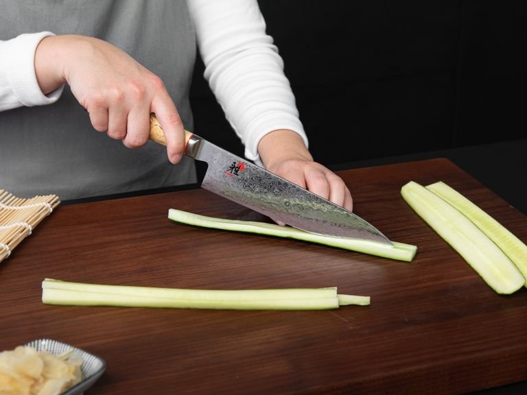 Quarter and deseed cucumber, then cut into matchsticks. Halve and pit avocado and cut the flesh into slices. Cut salmon into long strips. Halve dried seaweed sheets lengthwise and transfer to a sushi mat. Peel the sweet potato, cut into thin strips, transfer to a frying pan and fry until the sweet potato becomes soft.