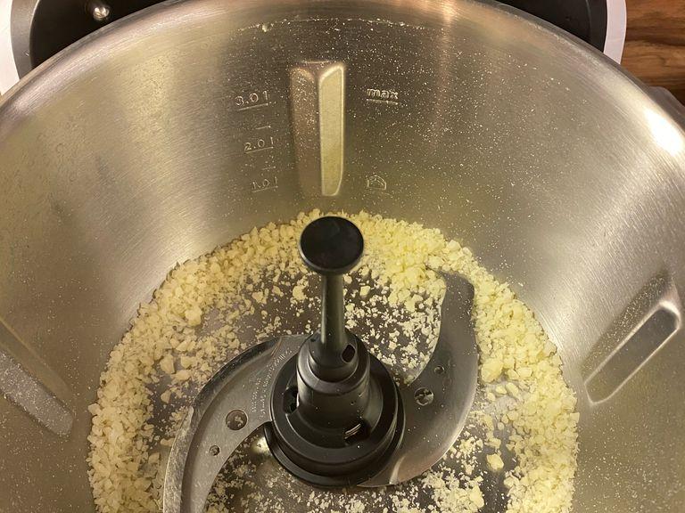 Backofen auf 180 Grad vorheizen. Das Universalmesser in den Cookit einsetzen, Parmesan in den Topf geben. Den Messbecher einsetzen, den Deckel schließen und alles zerkleinern. (Cookit Universalmesser | Stufe 18 | 30 Sek.)
