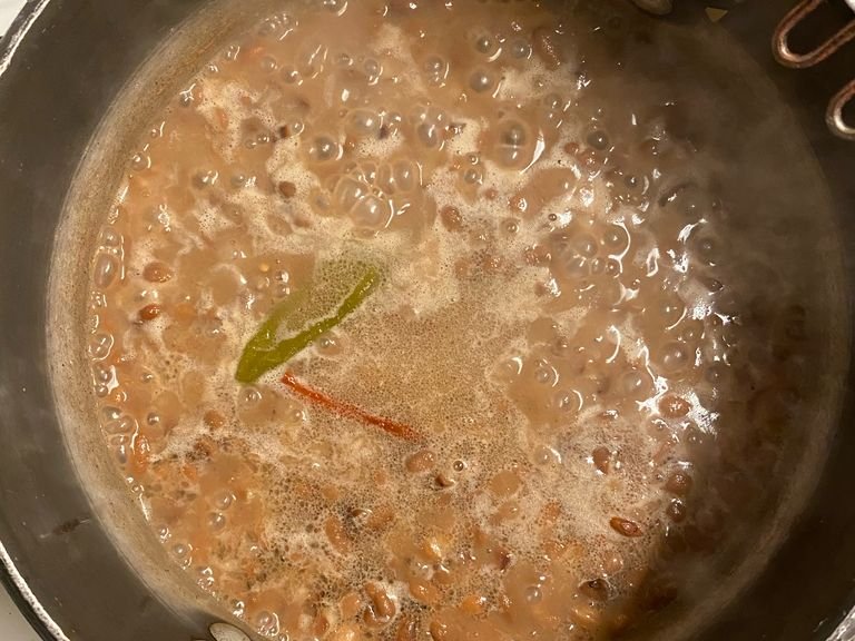 In a pot, add oil and beans. Medium/low heat. You can also add chiles, garlic, onion; or simply just the beans. Let them warm up and combine well with the oil.