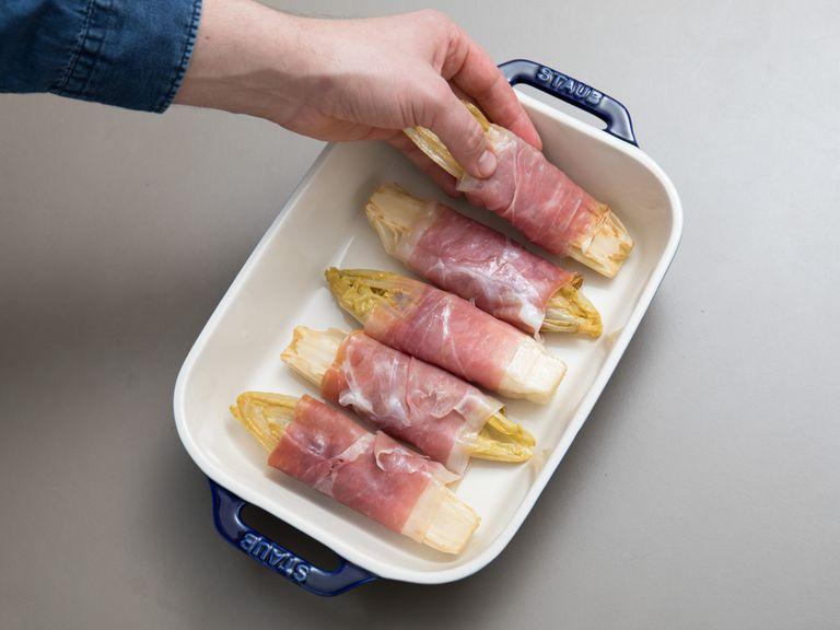 Heat some olive oil in the same frying pan. Fry the drained endives for approx. 2 min. per side, until lightly brown. Carefully wrap each half in a slice of prosciutto and transfer to a baking dish.