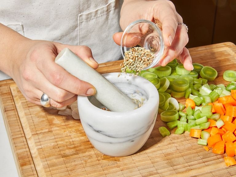 Peel and chop carrot, celery, and leek into bite-size pieces. Peel and thinly slice garlic cloves. Zest and juice lemon and set aside. Crush fennel seeds and coriander seeds with a mortar and pestle.