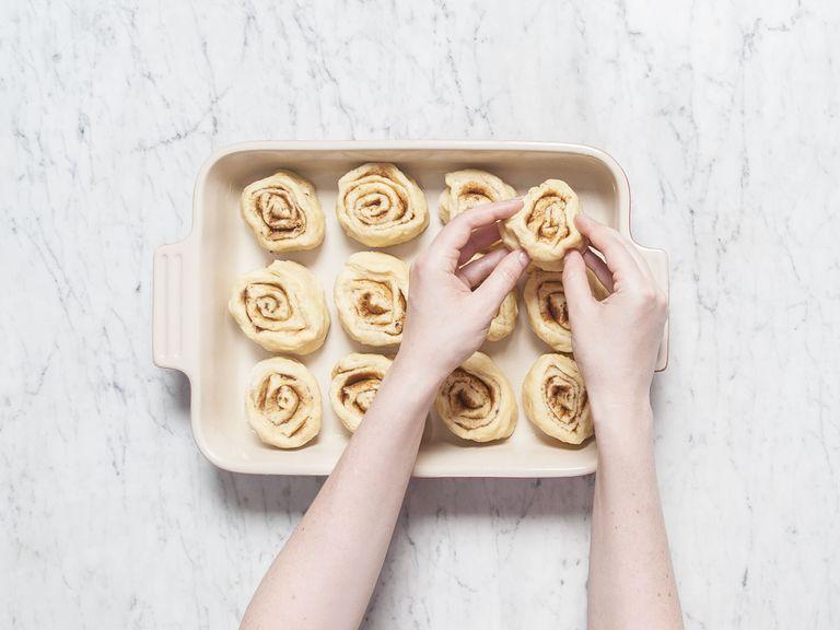 Roll up the dough like a carpet, starting from the long end. Cut the roll crosswise into equal-sized pieces, each approx. 3-cm/1-inch thick. Transfer into greased baking pan. Cover with a kitchen towel and let rise in a warm place for approx. 90 min.