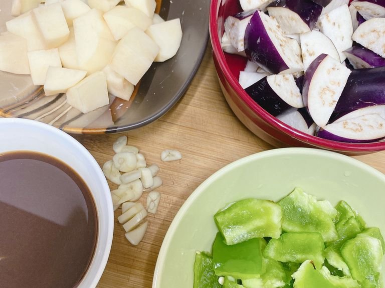 Cut the three vegetables into pieces. Potatoes can be cut into slices—it would be easier to fry. Slice the garlic. Mix all the other ingredients except for the oil & garlic together as the brown liquid in the left corner.