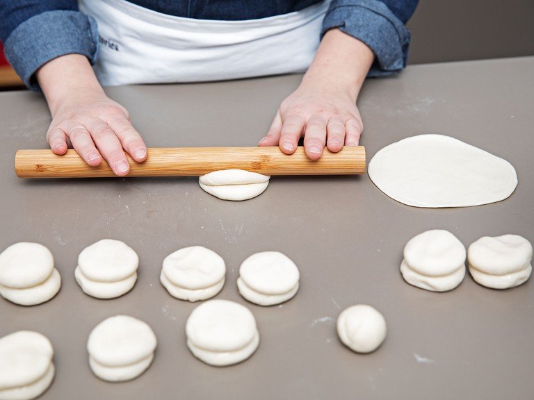 For the pancakes, roll dough into a thin log and divide into  approx. 24 equal pieces. Roll into balls and gently press them down. Brush half of them with some oil, then press another dough ball on top of each (at this point you’ll have 12 stacks of two dough balls each). On a floured working surface, roll each stack of dough balls into thin pancakes.