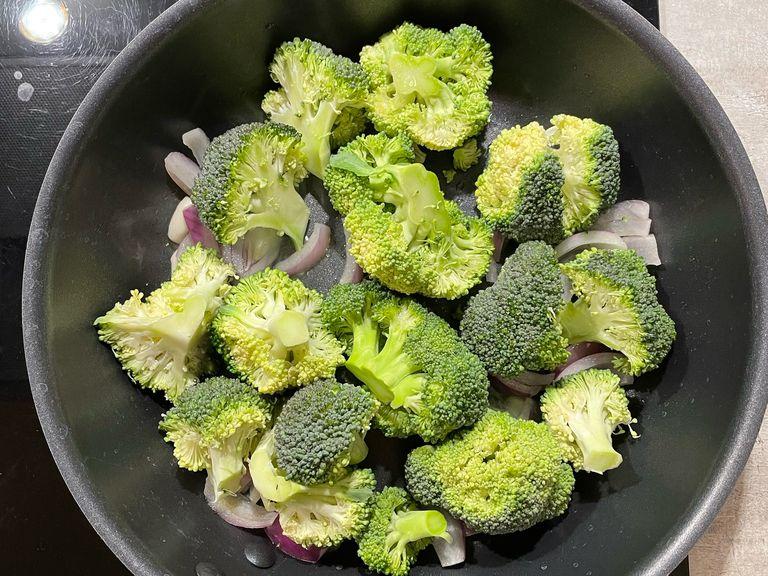 Add oil and onion to a cooking pan, then add the cut broccoli head. After a few minutes you can add salt, pepper and some water. Let it cook for around 10 minutes.