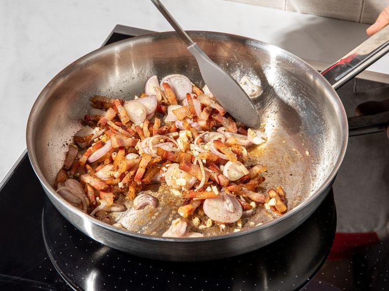 Pancetta mit etwas Olivenöl in eine Pfanne geben und braten, bis das Fett transparent und weich wird, ca. 5 Min.. Schalotten, Knoblauch und Chili dazugeben und bei mittlerer Hitze weiterbraten, bis sie glasig werden. Großzügig mit schwarzem Pfeffer würzen. Tomaten aus der Dose dazugeben und bei mittlerer Hitze ca. 10 Min. köcheln lassen. Währenddessen die Rigatoni nach Packungsanleitung kochen. Rigatoni abgießen und dabei etwas Kochwasser für die Soße auffangen.