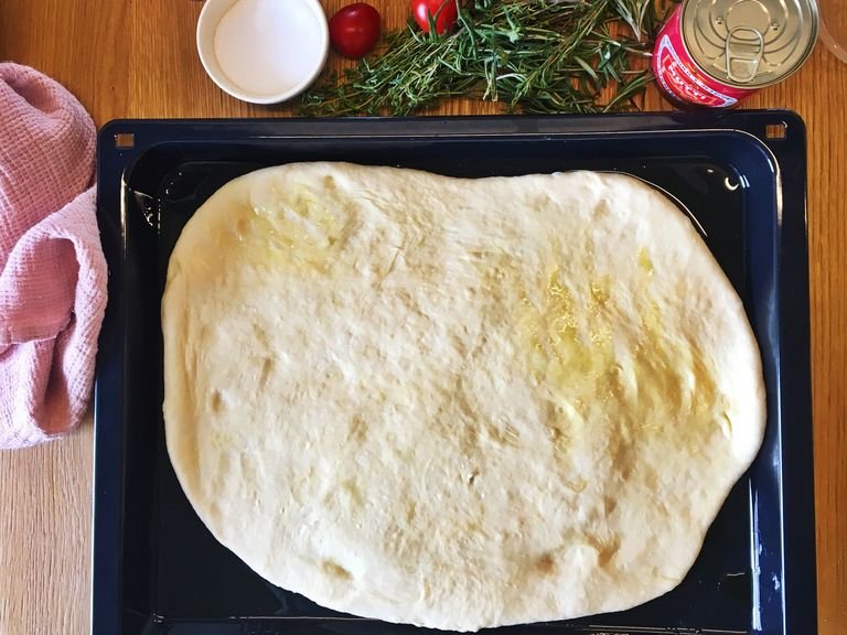 Grease a baking sheet with olive oil and carefully transfer the dough to the baking sheet.