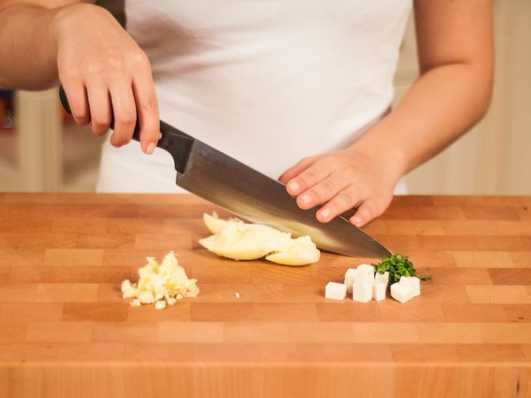 Backofen auf 180°C vorheizen. Tofu würfeln. Petersilie und das Innere der Zucchini grob hacken.