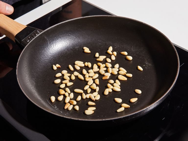 In the meantime, toast pine nuts in a dry frying pan until fragrant and browned, approx. 4 min, tossing often. Pluck the basil and parsley leaves from the stems and zest the lemon. Grate Parmesan cheese.