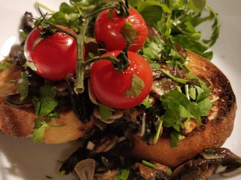 Take the slice of bread out from the grill when toasted and rub with the extra clove of garlic. When coated, tip over the mushrooms and top with the grilled tomatoes. Finish with a sprinkle of sea salt and the remaining parsley.