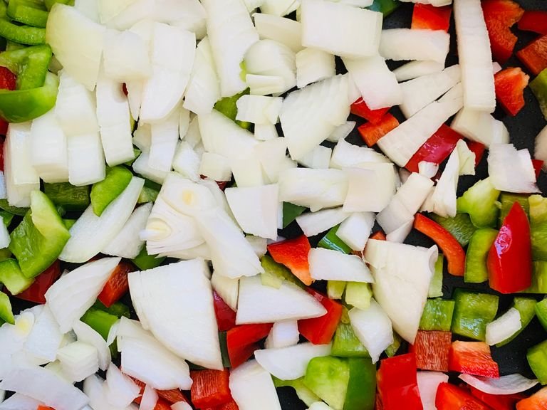 Boil the rice. Prepare the vegetables and cut them into dices. Cut the sausage in pieces. Heat some oil in the pan and fry the peppers and onion for about 5 minutes on a medium heat. 