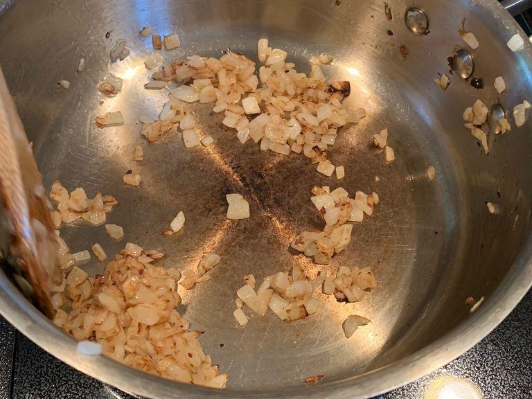 Die gehackten Zwiebeln in einen Stieltopf geben und goldbraun karamellisieren.