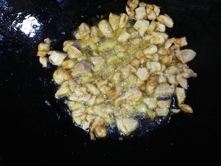Add chicken to a wok and fry until golden brown.