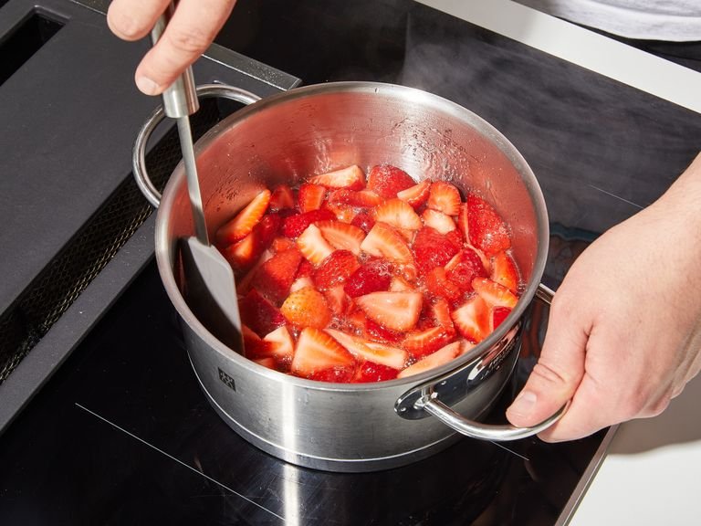 In der Zwischenzeit die Erdbeersoße zubereiten. Dazu den Topf mit den Erdbeeren auf mittlere bis hohe Hitze stellen. Zum Kochen bringen, dann die Hitze reduzieren und ca. 5 Min. köcheln lassen, bis die Mischung leicht einzudicken beginnt. Vom Herd nehmen und beiseite stellen, während du die Pfannkuchen zubereitest.