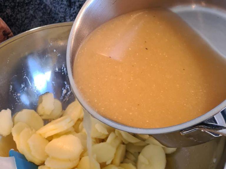 Die warmen Kartoffelscheiben nach und nach in eine Schüssel geben und schrittweise die heiße Brühe darüber gießen. Viel umrühren, so dass die Brühe in die Kartoffeln ziehen kann und der Kartoffelsalat schön "schlotzig" wird. Auf keinen Fall die ganze Brühe auf einmal in die Schüssel zu den Kartoffeln schütten!!