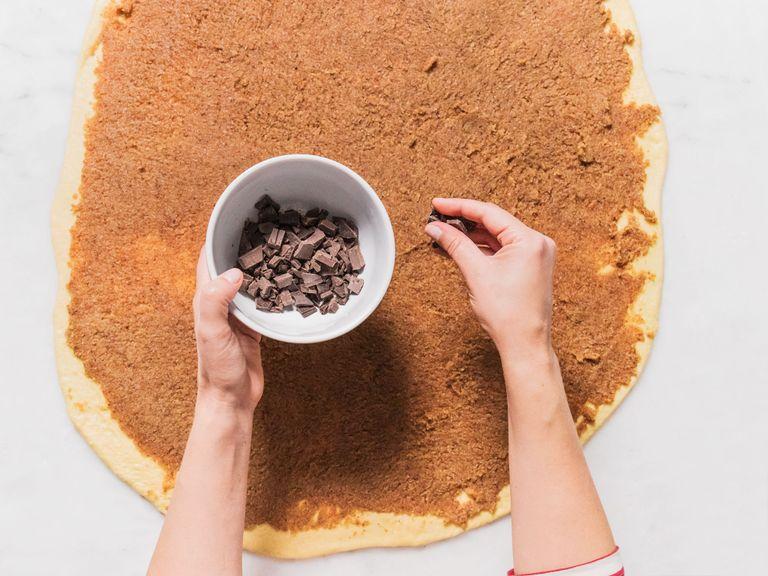Preheat oven to 180°C/350°F. Chop chocolate. Turn dough out onto a clean work surface and roll to ½ or ¼ in. thickness. Spread filling evenly in a thin layer over dough all the way to the edges, using your hands as needed. Sprinkle with chocolate shavings, and roll dough into a tight log.