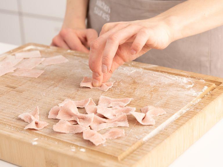 To make farfalle, roll out the dough at the thinnest level of the pasta machine and cut it into 2-in. (5 cm) wide strips with a knife. Then cut squares with a pizza wheel (or a pasta cutter if you have one). Fold them twice in the middle with your fingers to create the classic bowtie shape.