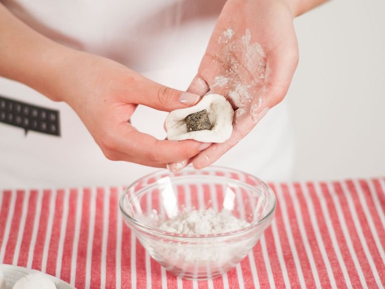Lightly cover hands with rice flour. Take a small portion of the dough (approx. 1 tablespoon) and form a small dough round. Place filling in the center and wrap dough around to form a ball. Cover with rice flour.
