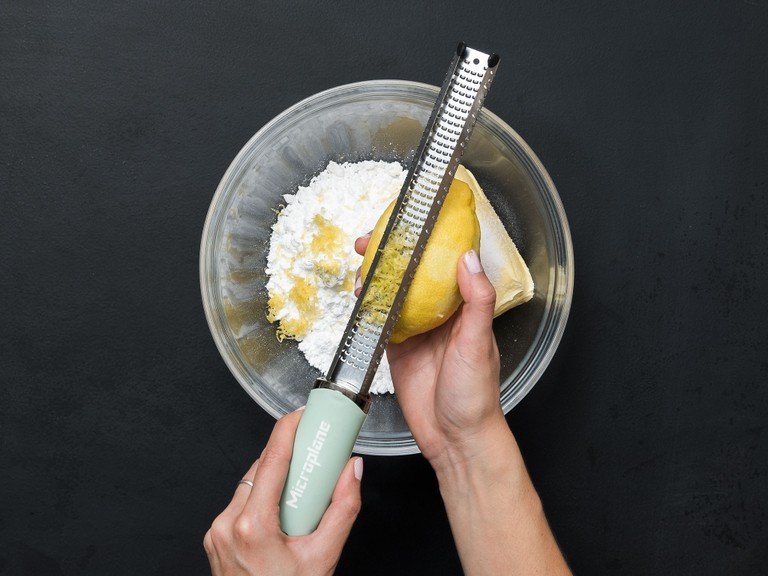 Backofen auf 180°C vorheizen. Butter, Puderzucker, Vanillezucker, Salz und Zitronenabrieb in eine große Schüssel geben und für ca. 5 Min. verrühren. Eier zugeben und ca. 1 weitere Min. mixen.