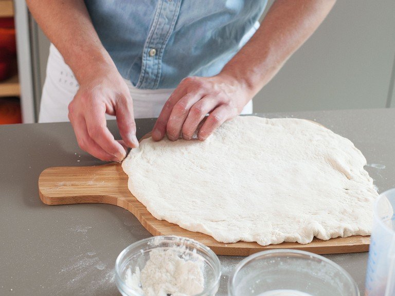 Remove dough from bowl. On a floured work surface, flatten out to approx. the size of the pizza stone. Transfer to a pizza paddle.