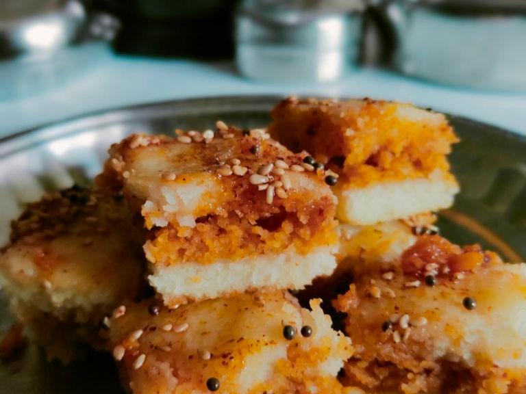 The final step once the dhokla is prepared cool it aside and take a pan heat oil into it add mustard seeds, sesame seeds, curry leaves and add some chilli powder as per your taste and add it over dhokla and cut it into pieces and serve with sauce or chutney.