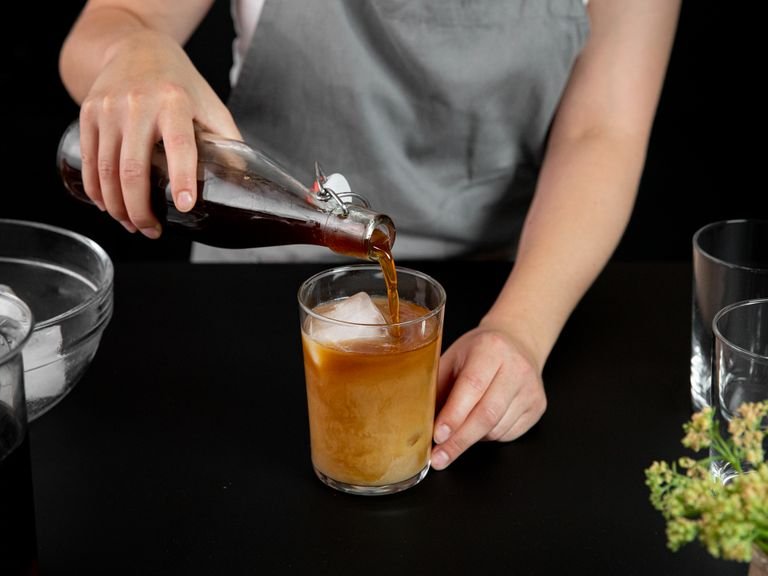 Für einen klassischen Cold Brew Latte Eiswürfel, Cold Brew Kaffee und Milch in ein Glas geben und auf der Stelle genießen. Falls gewünscht, kann ein beliebiger Sirup hinzugefügt werden.